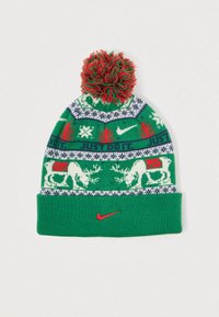 Gorro de malha verde com padrão festivo de rena, flocos de neve e texto "FAZ O QUE TEM A FAZER". Finalizado com um pompom vermelho e verde e um logo vermelho da Nike.