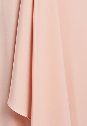 Tissu de couleur pêche avec une texture lisse et douce, tombant élégamment avec un éclat subtil. Présente des plis fluides aux bords nets.