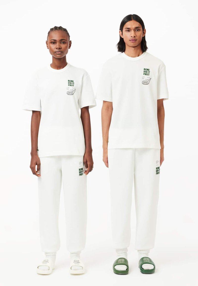 T-shirts et joggers en coton blanc avec des textes et graphiques verts. Chaussons : blancs avec du texte et verts avec un logo. Design minimaliste et décontracté.