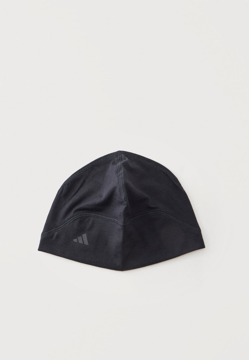 Bonnet de sport noir avec des coutures discrètes et un petit logo réfléchissant sur un côté, posé à plat sur un fond blanc.