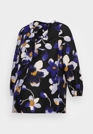 Blouse noire à manches longues avec des fleurs violettes, blanches et jaunes, col en V et poignets froncés.