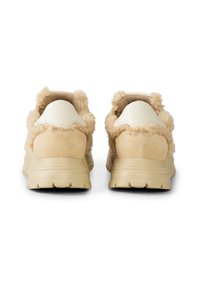 Béžové tenisky s měkkými, textura podobnými kožíškovými akcenty na límci, hladkým koženým podpatkem a robustní gumovou podrážkou.