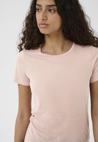 Hellrosa Kurzarm-T-Shirt aus einem weichen, glatten Stoff mit Rundhalsausschnitt und figurbetonter Silhouette, auf einem neutralen Hintergrund präsentiert.