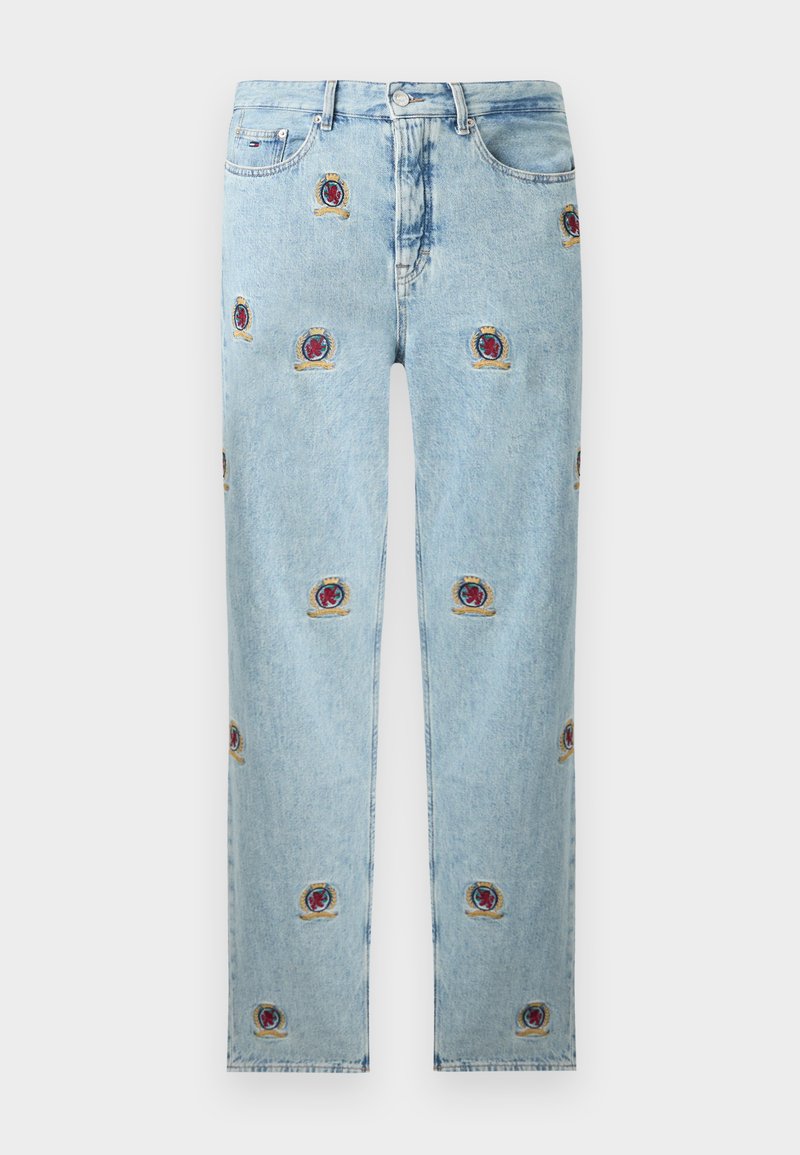 Lyseblå denimjeans med røde og gullbroderte våpenmønstre spredt over foran og sidelommene.