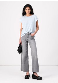 Lyseblå stripete t-skjorte, grå vide jeans, svarte platå-sko og en svart håndveske. Glatt stoff, uformelt design og avslappet passform.
