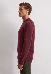 Bordeaux gebreide trui met een ronde hals, geribde manchetten en zoom, met een gestructureerde afwerking en een slanke, aansluitende pasvorm.