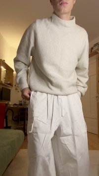 Heledhall hall kaelusega heledates hallides ribades kampsun koos avarate valgete pükstega, millel on küljetaskud ja nöörvöö.