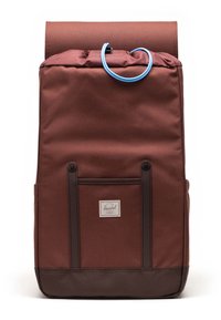 Mochila marrón con cierre enrollable, cordón y acentos azules. Presenta un tejido texturizado, bolsillo frontal y base oscura en contraste.