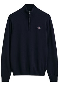 Marineblauwe trui met hoge kraag en een halve rits, gemaakt van een zachte stof. Bevat een klein logo op de linker borst en ribgebreide manchetten.