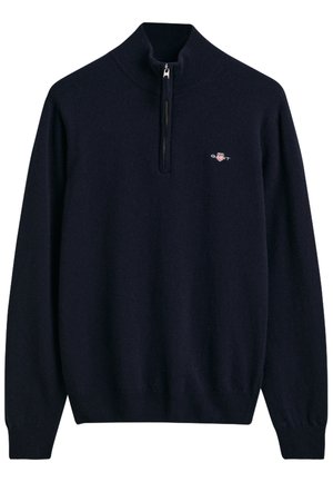 Pull marin avec un col montant et une demi-fermeture éclair, fabriqué à partir d'un tissu doux. Présente un petit logo sur la poitrine gauche et des poignets côtelés.