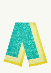 Grün-gelb gemusterter Schal mit strukturierter Oberfläche, der auffällige Punkte, Fransenränder und ein Design mit dem Text "CASUAL IDENTITY" aufweist.