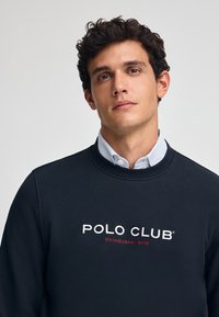 Sudadera azul marino de algodón mezclado, con texto bordado en blanco "POLO CLUB" y "ESTABLISHED 2012" en rojo.