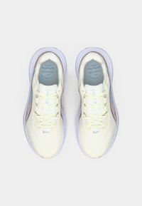 Αθλητικά παπούτσια ανοιχτού κίτρινου χρώματος με ανθεκτικό πλέγμα στο επάνω μέρος, μπλε λεπτομέρειες και μαλακή μοβ σόλα. Διαθέτουν υφασμένα κορδόνια και λογότυπο.