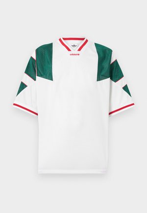 Biała koszulka z zielonymi akcentami siateczkowymi na ramionach. Czerwone wykończenie na linii dekoltu i brzegach rękawów. Z geometrycznymi liniami wzoru. Zawiera logo Adidas.