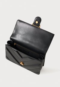Borsa a mano in pelle nera con una texture liscia, motivo a zigzag sulla parte frontale, dettagli in oro e chiusura a scatto. Interno dotato di tasca con zip.