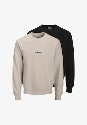 To langærmede crewneck sweatshirts, en beige med "JJ Studios" tekst på forsiden og en ensfarvet sort, præsenteret mod en hvid baggrund.