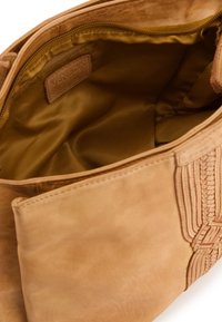 Tan lædertaske med et struktureret, flettet design, der har en glat overflade og en foret indvendig i en afdæmpet guldfarve.