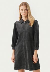 Dunkelgraues Cordrouykleid mit kragenlosem Ausschnitt, langen Puffärmeln, Frontreißverschluss und einer taillierten Taille mit schwingendem Rock.