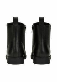 Stivaletti alla caviglia in pelle nera con cerniere laterali e linguette per tirare, mostrati da dietro su uno sfondo bianco.