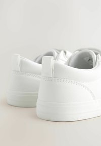 Weiße Sneakers aus Kunstleder mit glatter Textur, runder Form und minimalistischem Design. Verfügt über dezente Nähte und eine Fersenschlaufe.