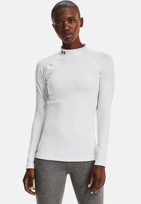 White long-sleeve athletic shirt with a high neck, made from smooth material. Features a small black logo at the collar and fitted design.