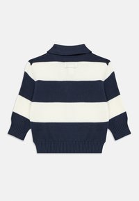 Πλεκτό πουλόβερ με ναυτικό μπλε και λευκές ρίγες, με διπλωμένο γιακά, ριμπ μανσέτες και τελείωμα. Διαθέτει μικρή ετικέτα στο πίσω μέρος. Μανίκια μέτριου μήκους.