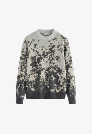 Pull en tricot gris clair et beige avec un motif camouflage ; présente un col rond et des bords-côtes aux poignets et au bas. Texture douce.