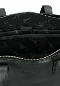 Interior de un bolso de mano de cuero negro con bolsillo con cremallera y compartimentos, con un forro de tela negra estampado con el logo "Plevier".