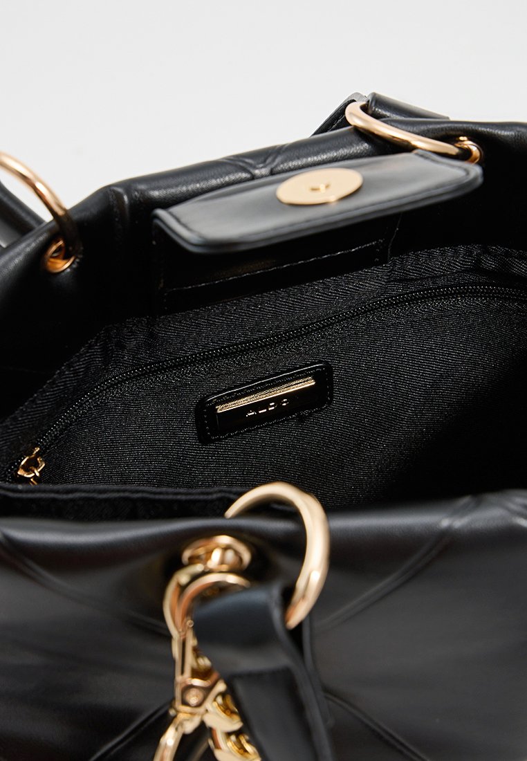 Sac à main en cuir noir avec quincaillerie dorée, présentant un design matelassé, une fermeture supérieure et une poche intérieure zippée pour l'organisation.