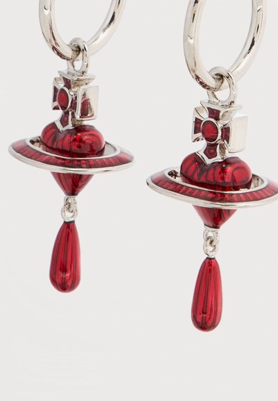 Κό κκινα σκουλαρίκια σε σχήμα σταγόνας με κυκλικό, πολυεπίπεδο σχέδιο διακοσμημένο με ασημένιο υλικό. Καμπυλωτά σχήματα και ριγέ υφή προσθέτουν λεπτομέρεια.