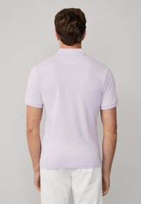 Světle fialová polo košile vyrobená z měkké směsi bavlny, s klasickým límečkem a krátkými rukávy, s jednoduchou texturou a jemnými detaily šití.