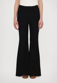 Black flared pants with a smooth, structured fabric; mid-rise waistband and belt loops. Features wide legs extending to the floor.