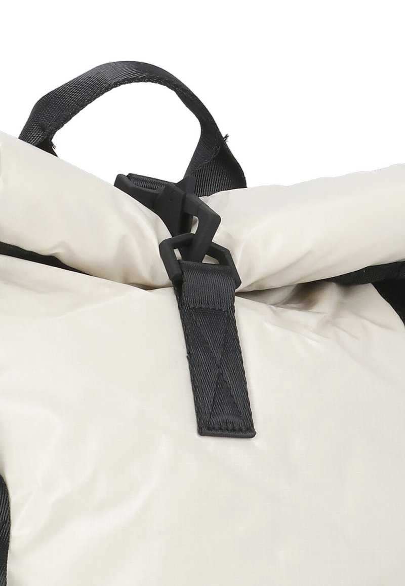 Zaino roll-top realizzato in tessuto impermeabile di colore crema, con accenti e hardware neri, tra cui una chiusura a fibbia e una maniglia di trasporto.