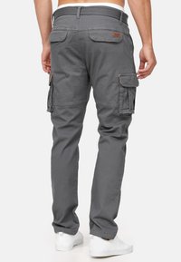 Pantaloni cargo grigi in misto cotone, con numerose tasche laterali, un tessuto strutturato e una vita con cordoncino. Tasca posteriore con dettagli del marchio.