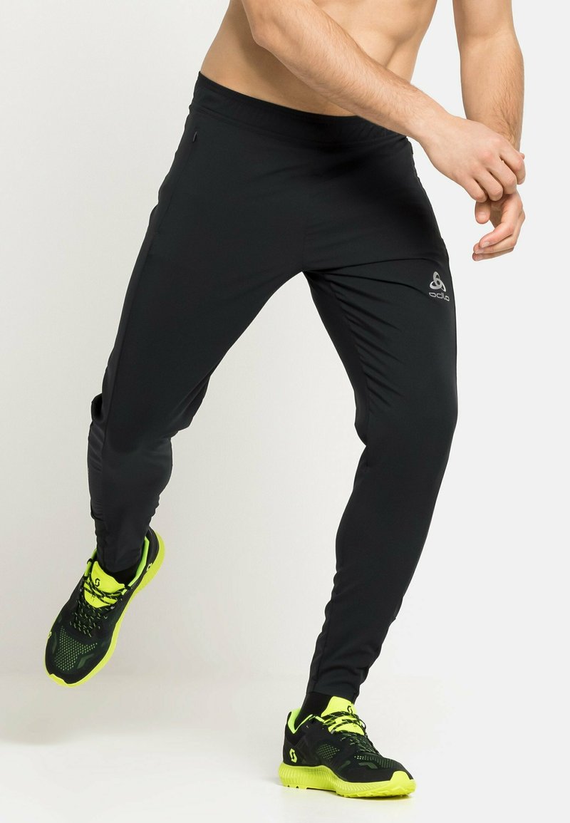 Pantalones deportivos negros con un diseño ajustado y cinturilla elástica. Cuenta con un logo reflectante y una textura suave y ligera.