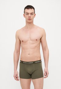 Boxers vert olive en coton doux, avec une ceinture noire portant le nom de la marque "JACK & JONES" imprimé en blanc.