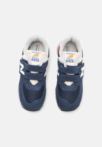 Sneakers New Balance 574 blu navy in materiali suede e mesh, con strap in Velcro, dettagli bianchi e arancioni, e colletto imbottito.