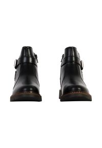 Botas de tobillo de cuero negro con punta redondeada, hebillas laterales y suela de madera. Textura suave y diseño minimalista.