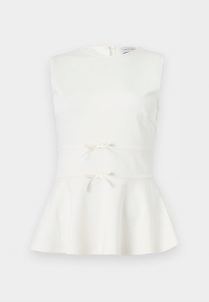 Ermeløs hvit peplum-topp med to små dekorative sløyfer i midjen og rund hals.