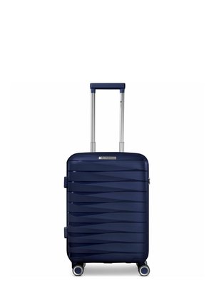 Valigia rigida blu navy con scanalature diagonali testurizzate, quattro ruote girevoli e una maniglia telescopica estesa, centrata su sfondo bianco.