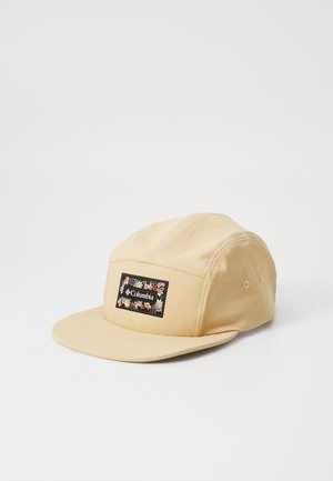 Casquette beige à cinq panneaux avec visière plate et patch rectangulaire noir présentant un motif floral et le logo "Columbia" à l'avant.