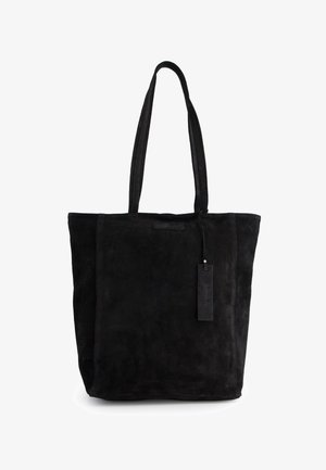 Schwarze Wildleder-Tote mit zwei langen Tragehenkeln, rechteckiger Form, äußeren Nahtdetails und einem angehängten Etikett für Branding.