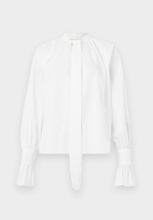 Bela dolgosleeve bluza iz bombaža z mandarin ovratnikom, detajlom vezanja in nabranimi manšetami. Gladka tekstura in minimalistična zasnova.