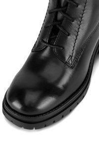Czarne skórzane botki za kostkę o gładkim wykończeniu, zaokrąglonym nosku, dekoracyjnym przeszyciu i sznurowanym przodzie. Solidna gumowa podeszwa z dobrą przyczepnością.