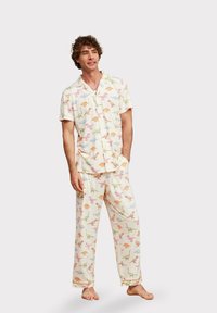 Korte mouw pyjama set met een licht roomkleurige achtergrond en kleurrijke dinosaurussen prints. Gemaakt van zachte stof met een ontspannen pasvorm.