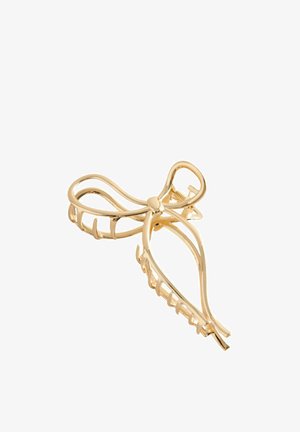 Gold metal hair clip shaped like an abstract bow with an open, curved design and interlocking teeth for securing hair.