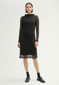 Schwarzes Kleid mit enganliegendem Oberteil, durchsichtigen langen Ärmeln und halbtransparentem Saum. Glatte Textur, entworfen für eine schlanke Silhouette.