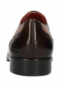 Chaussure en cuir marron avec une finition lisse, des coutures détaillées et un bout arrondi. Dispose d'une semelle noire et d'un revêtement intérieur rouge.