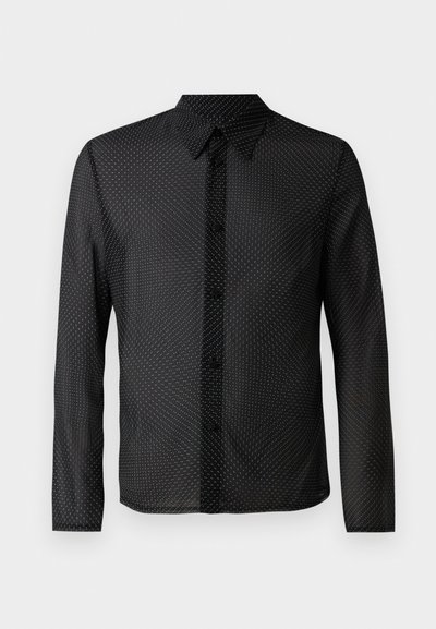 Melnā krekls ar pogu aizdari, garām piedurknēm un baltu punktiņu rakstu, izgatavots no viegla, caurspīdīga auduma.