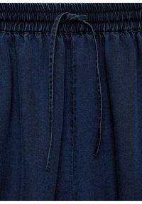 Marineblau, leichtes Gewebe mit einem gerafften, elastischen Bund. Verfügt über eine Kordelzugdetails und eine weiche Textur. Geeignet für legere Kleidung.